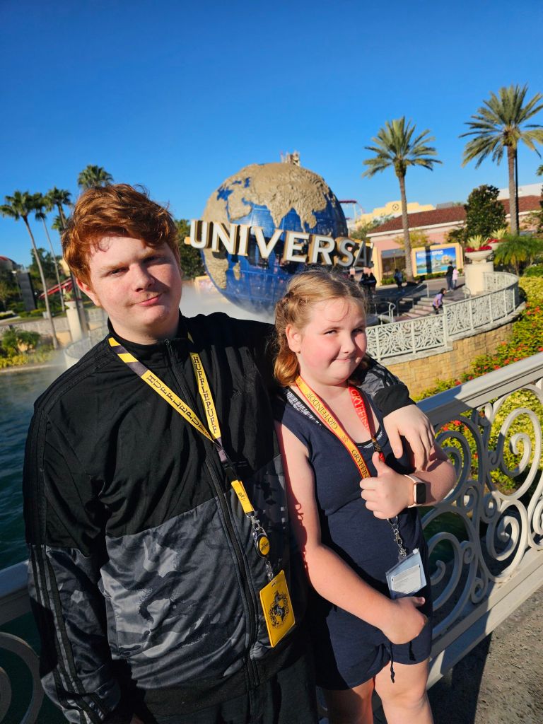 "Two budget-savvy travelers pose in front of the iconic Universal Studios globe, proving that memorable experiences don't require a luxury budget."